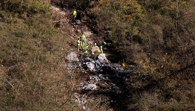 Operarios de Adif, en tres momentos del proceso para retirar la roca de gran tamaño que amenazaba con caer sobre el trazado ferroviario en Lena.