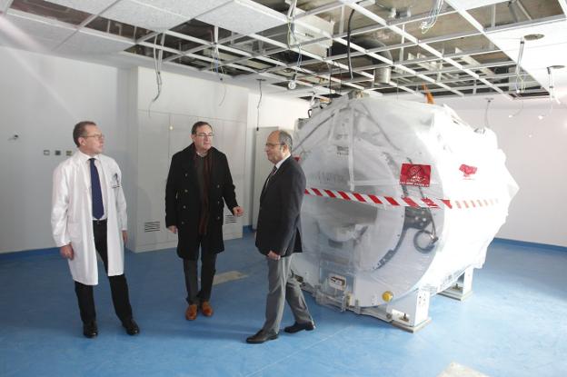 El director de Atención Sanitaria y Salud Pública del Área Sanitaria IV, José Antonio Vecino, José Ramón Riera y Germán de Juan, junto a la nueva resonancia magnética instalada en el HUCA. 