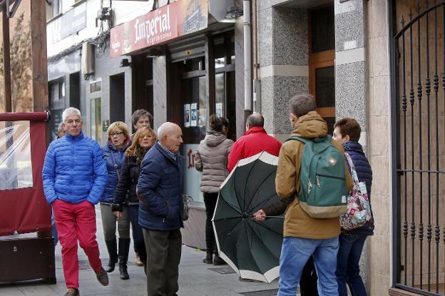 Varios vecinos, frente a la cafetería Imperial, asaltada el pasado viernes. 