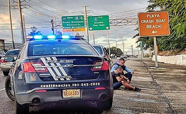 La enternecedora historia detrás de la foto de un policía que consuela a un hombre en la vía