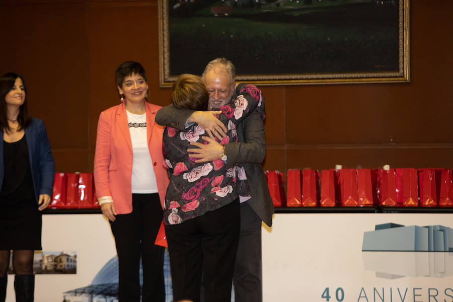 Ana Suárez Guerra y Concepción Saavedra observan el abrazo de Enrique González a Natividad Fernández Suárez, que trabajó como auxiliar administrativo.. 