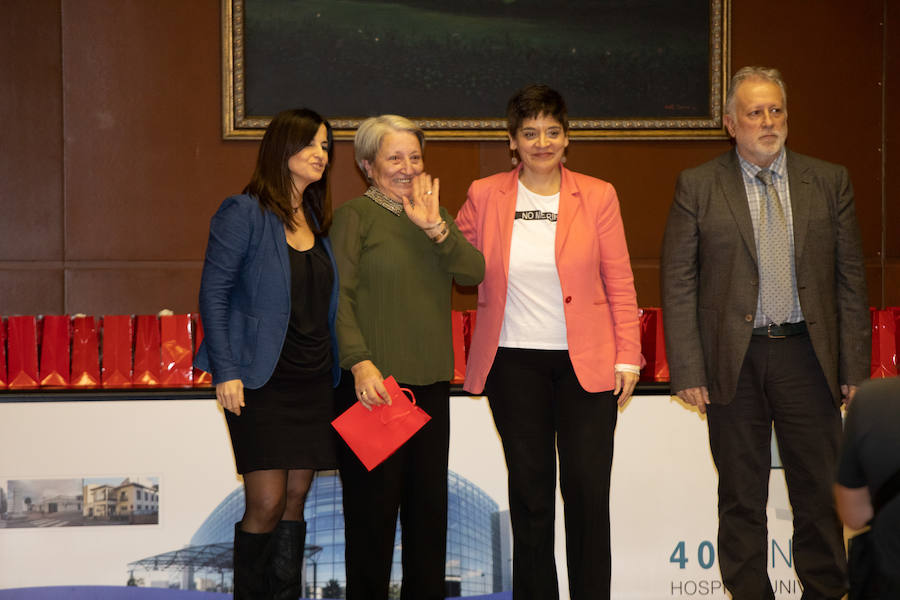 Flores Gómez Paz, que ejerció de auxiliar de enfermería en el Centro de Salud de Corvera, saluda a sus compañeros desde el escenario del salón de actos del Hospital Universitario San Agustín. 