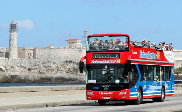 Un autobús turístico atraviesa la zona del Malecón de La Habana.