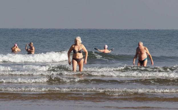 Bañistas este martes en la playa de San Lorenzo, Gijón. 