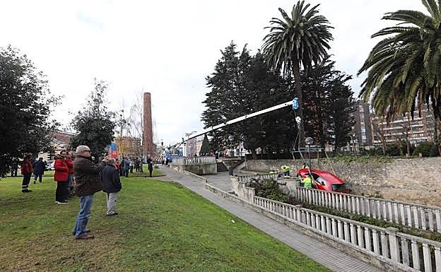 Tareas de rescate del vehículo encajonado en una acera. 