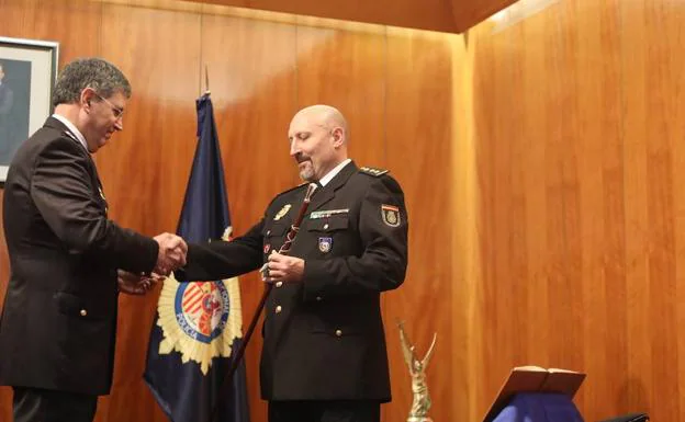 El jefe superior de Policía de Asturias, Juan Jesús Herranz, entrega el bastón de mando al nuevo comisario Gregorio Valverde Verdugo. 
