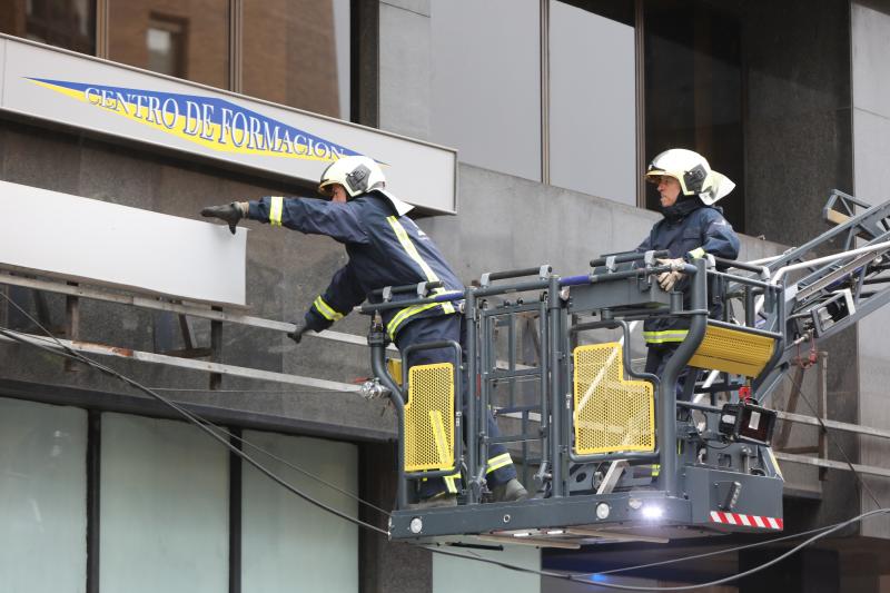 La ventosa jornada ha dejado papeleras y carteles caídos y un carretera cortada por un árbol en Naveces