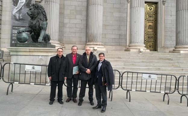 El asturiano Miguel Francés, presidente de la Federación de Tiro, y Ángel López, presidente de la Federación de Caza, en el centro, con dos colaboradores, a las puertas del Congreso 