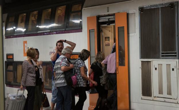 Varias personas entran en un coche de Rodalies. 