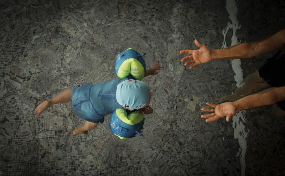 El pequeño Román Tuñón, de dos años y con síndrome de Down, aprende a nadar con su abuela.