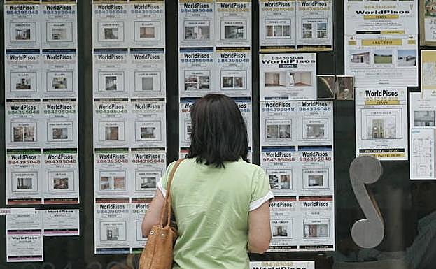 Una mujer consultan la oferta de alquiler. 