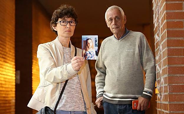 Isabel Santiago y Roberto Álvarez mostrando una foto de su hija cuando estaba desparecida.