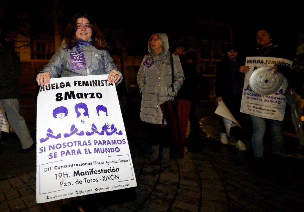 Un veintena de personas comenzó la jornada de huelga general feminista con una pega de carteles convocando a la manifestación de esta tarde en Gijón