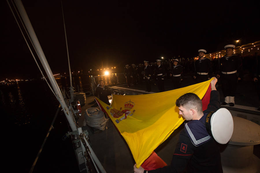 Los marinos se preparan para plegar la bandera una vez arriada. 