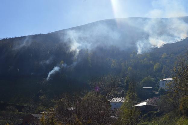 La humareda cubre el pueblo de Tejedal, en Tineo, tras mantenerse activo el fuego todo el día. 