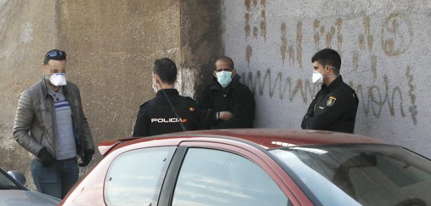 Agentes de la Policía Nacional asisten al enfermo junto al albergue. 