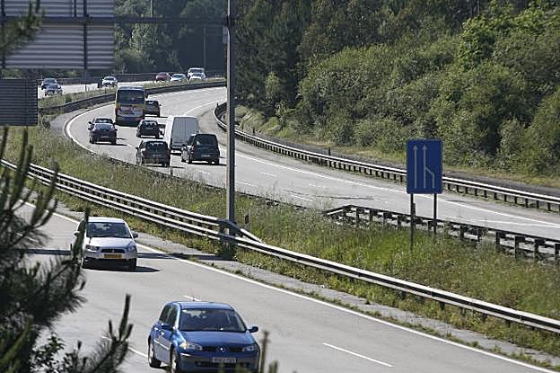 Tráfico en el nudo de Serín. A la derecha, la calzada en sentido a Avilés, con la brecha abierta en el firme tras la señal. 