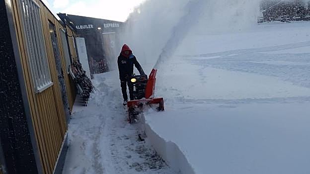 Fuentes de Invierno. Una máquina limpia el acceso a la tienda de alquiler de material. 