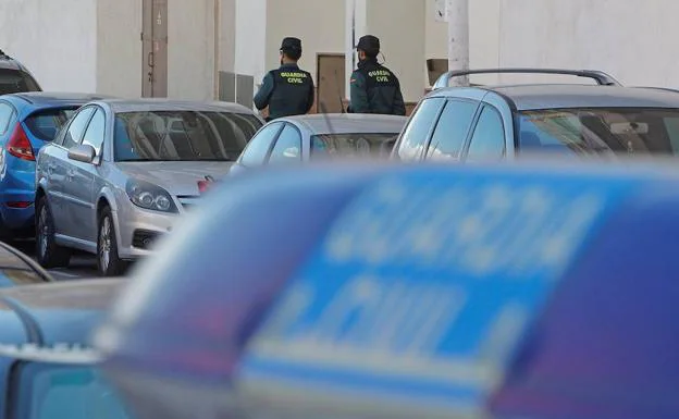 Dos guardias civiles, a la puerta del inmueble donde apareció este domingo muerta una ciudadana marriquí, en Torrevieja (Alicante)