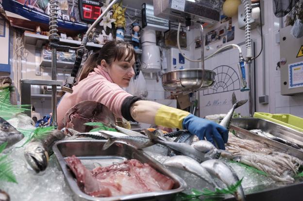 Ana Castiello, en su puesto del gijonés Mercado del Sur, coge una xarda. 