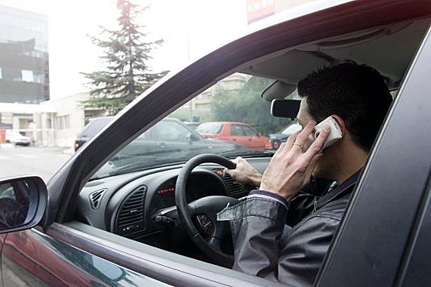 Un conductor habla por teléfono en el coche. 