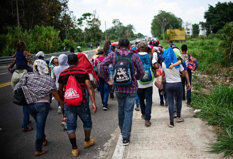 Los migrantes centroamericanos que se dirigen a los Estados Unidos caminan en caravana a lo largo de la carretera entre Metapa y Tapachula en México