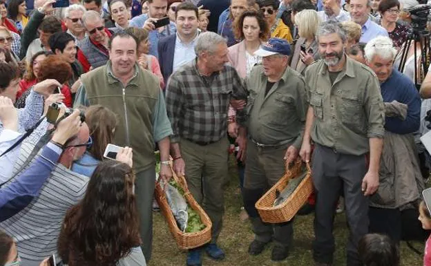 Rodeados de aficionados, Fernando López, con el campanu de Asturias, y Manuel Fernández, con el del Narcea, llegan a la subasta de Cornellana. 