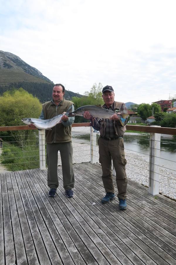 Laureano Toraño, a la derecha, con el tercer salmón del Cares, junto a su compañero Fernando López, que posa con el campanu, frente al río Cares, a la altura de Panes.