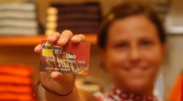 Una usuaria muestra una de las anteriores tarjetas con el logo. 