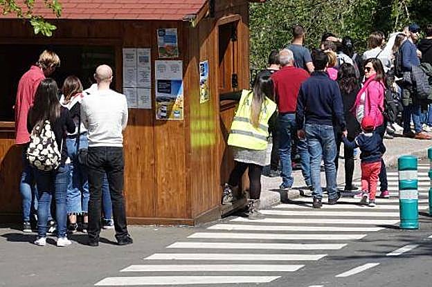 Oriente. Un grupo intenta comprar un pasaje para subir a Los Lagos y sumarse a la cola de turistas que espera la llegada del autobús para acceder al Enol y al Ercina. 