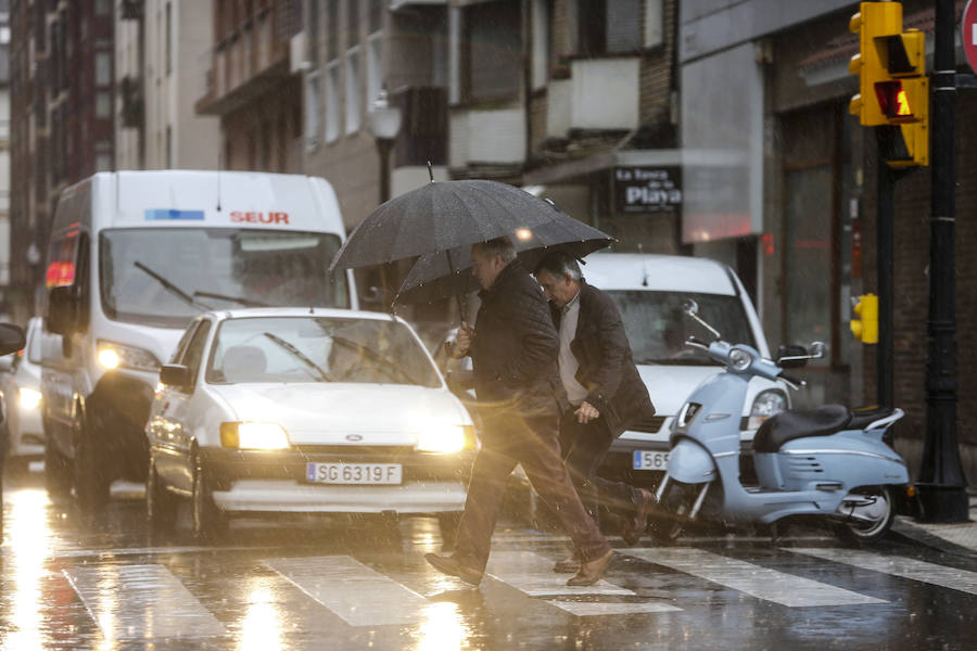 Aunque la mañana había librado del agua, las lluvias hicieron su aparición en Gijón por la tarde, con intensidad y acompañadas de tormenta