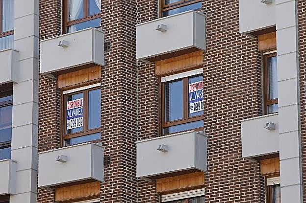 Una vivienda en un barrio gijonés con carteles de 'disponible' en sus ventanas. 