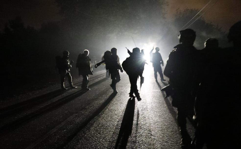 Sin apenas luz, militares y civiles recorren el camino que conduce a La Morgal. 