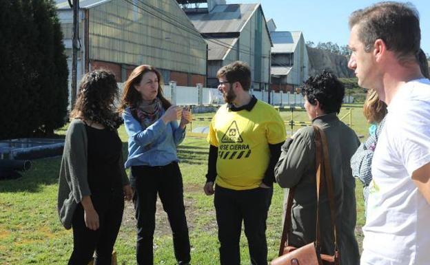 Lorena Gil, candidata de Podemos a la presidencia del Principado, con trabajadores de Alcoa en la entrada de la planta de Avilés.