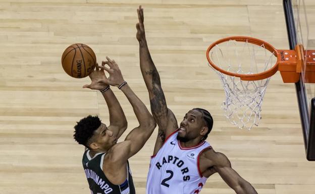 Kawhi Leonard trata de taponar un lanzamiento de Giannis Antetokoumpo. 