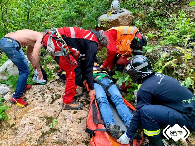 Los bomberos evacúan al herido. 