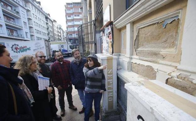 Los comerciantes muestran los daños que presenta el edificio a los ediles socialistas. / JUAN CARLOS ROMÁN 