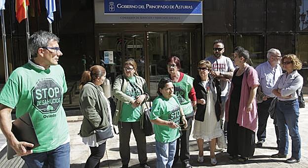 Miembros de la PAH acompañan a Belén Giménez (segunda por la izquierda) durante su reivindicación a las puertas de la consejería. 