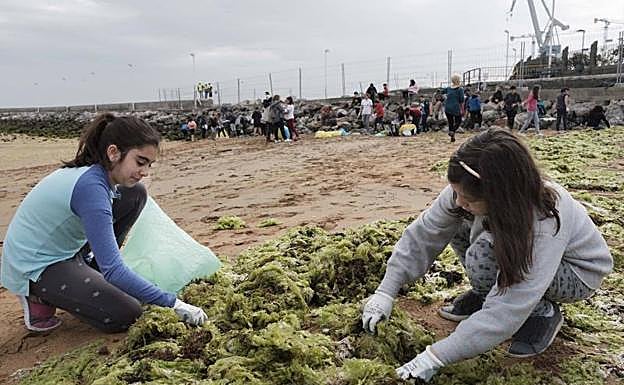 Dos de las alumnas participantes en la recogida de residuos de la playa del Arbeyal.