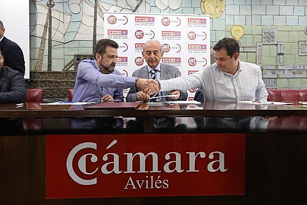 José Manuel Baltar (Comisiones Obreras) y Abel Suárez (UGT) estrechan la mano tras la firma del acuerdo por la industria ante la mirada del presidente de la Cámara, Luis Noguera. 