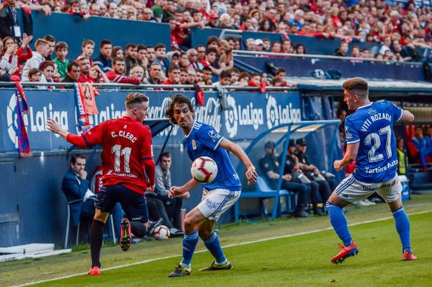 Carlos Martínez, que disputó en Pamplona su último partido con la camiseta oviedista, presiona a Clerc en presencia de Viti. 