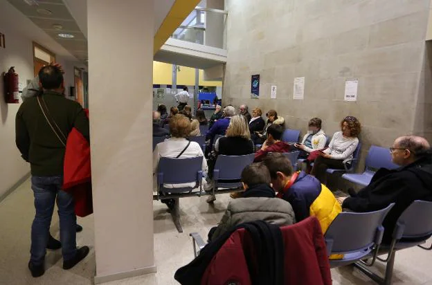 Una sala de espera del centro de salud Puerta de la Villa, de Gijón, con varios pacientes aguardando su turno. 