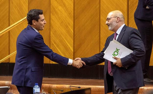 El presidente andaluz, Juanma Moreno, y el portavoz de Vox, Alejandro Hernández, se dan la mano esta tarde en el Parlamento de Sevilla.