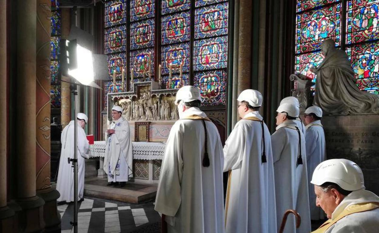 Particioantes con casco durante la misa.