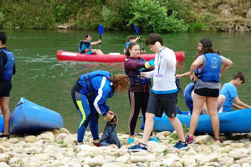 Un centenar de estudiantes del IES de Arriondas han aprovechado el descenso del Sella organizado por el centro para limpiar el río. 