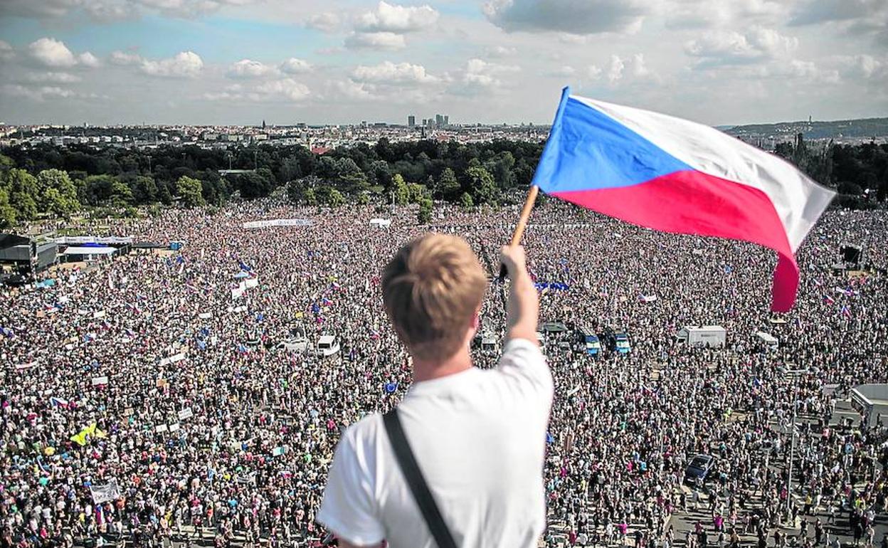Un joven agita una bandera checa ante la concentración de la plaza Letna.