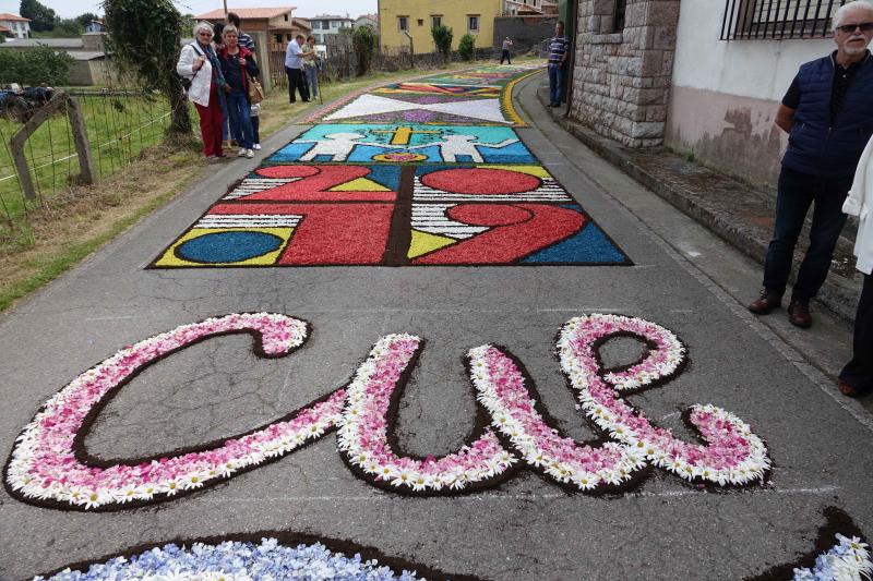 Las alfombras florales cubrieron las calles de la localidad llanisca de Cue, que ha celebrado la fiesta de la Sacramental. El disparo de 5.400 voladores puso el broche a la celebración.