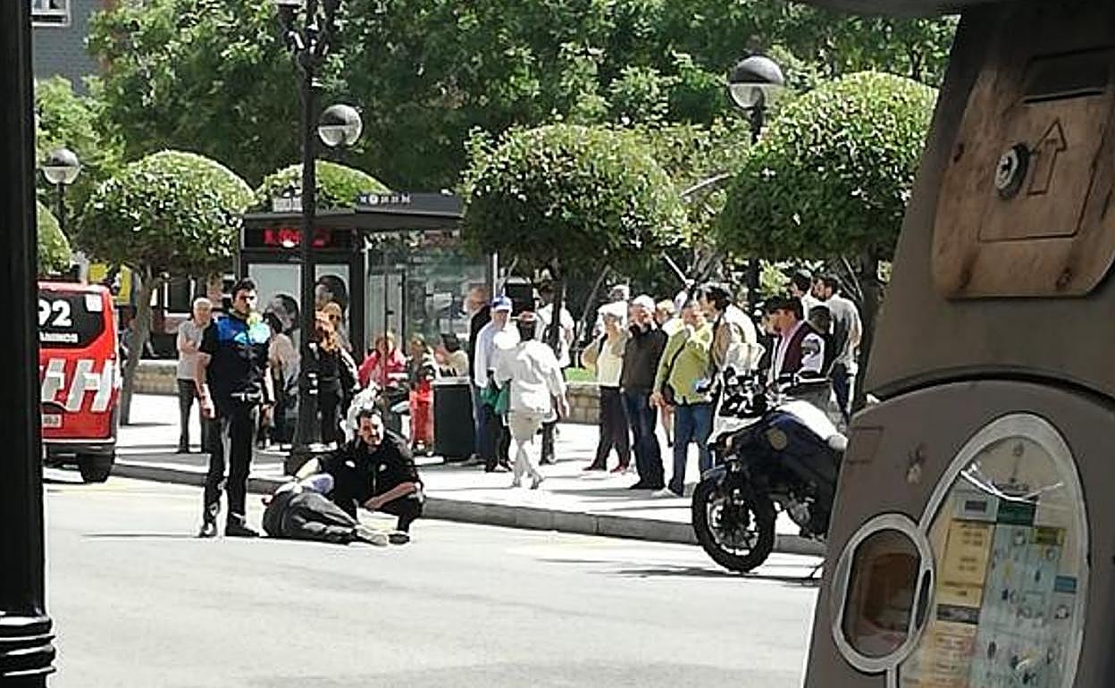 El herido, atendido por un agente de la Policía y un testigo antes de la llegada de los sanitarios. 