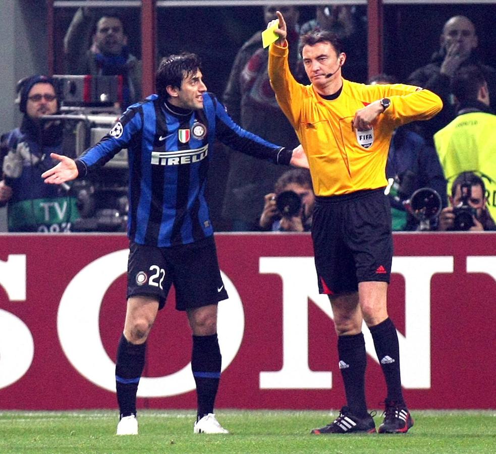 El árbitro asturiano Manuel Enrique Mejuto González muestra la tarjeta amarilla a Diego Milito durante el partido de Champions League disputado en San Siro entre el Inter de Milán y el Chelsea en 2010. 