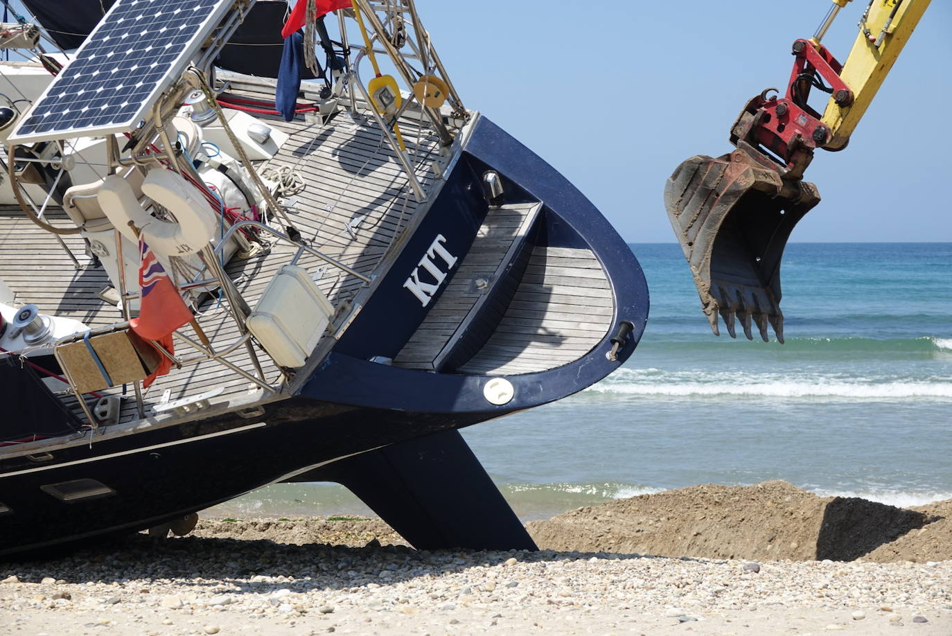 Una excavadora abre un canal en la playa de Santa Marina para intentar facilitar el posterior arrastre en pleamar del barco varado